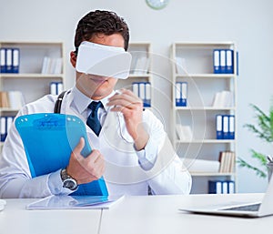 Young doctor with vr virtual reality headset working in the offi