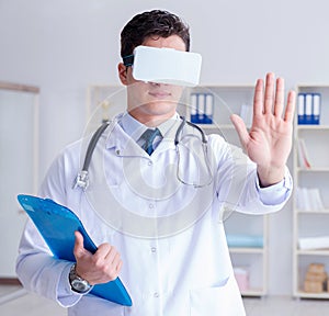 Young doctor with vr virtual reality headset working in the offi