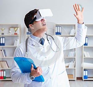 Young doctor with vr virtual reality headset working in the offi