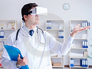 Young doctor with vr virtual reality headset working in the offi