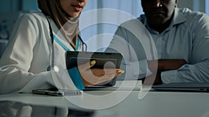 Young doctor woman in hijab medical worker nurse use electronic digital tablet show health test results on web screen to