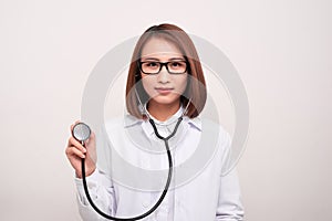 Young doctor woman holding stethoscope  on white background