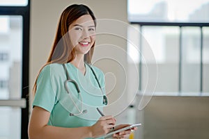 Young doctor woman smile face with stethoscope looking tablet co