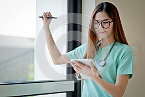 Young doctor woman smile face with stethoscope looking tablet co