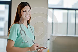 Young doctor woman smile face with stethoscope looking tablet co