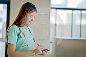 Young doctor woman smile face with stethoscope looking tablet co