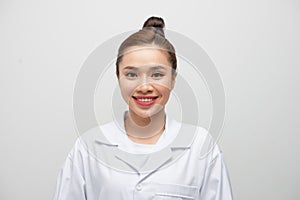 Young doctor woman wearing coat standing over isolated white background with a happy and cool smile on face
