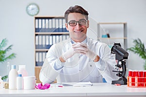The young doctor working in the lab with microscope