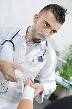 Young doctor working on patient at hospital