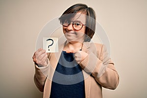 Young down syndrome business woman holding question mark paper as doubt symbol very happy pointing with hand and finger