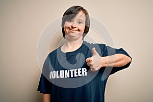 Young down syndrome volunteer woman wearing social care charity t-shirt doing happy thumbs up gesture with hand