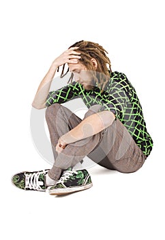 Young dreadlock man sits isolated