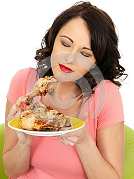 Young Dreamy Healthy Woman Holding Cold Cooked Chicken Drumsticks