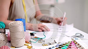 Young dressmaker draws women apparel sketch near mirror in fashion studio outfit designer