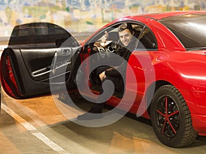 Young driver sitting in sport car showing thumbs up