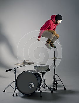 Young drummer jumping while playing