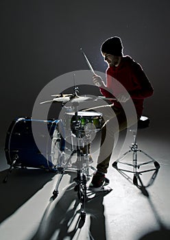 Young drummer playing in the contre light