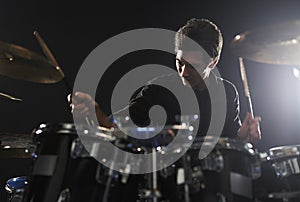 Young Drummer Playing Drum Kit In Studio photo