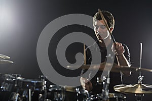 Young Drummer Playing Drum Kit In Studio photo