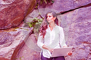 Young East Indian American Woman with long hair working on laptop computer outdoor in New York