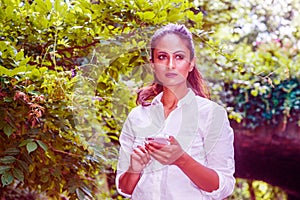 Young East Indian American Woman texting on cell phone outdoor at Central Park, New York