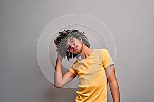 Young eastern man playfully touching his healthy beautiful curly hair