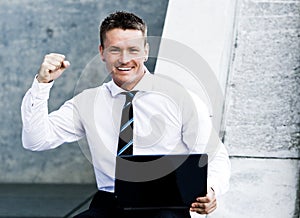 Young Elated Corporate Man With Laptop