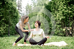 Young and elder woman doing yoga in the park