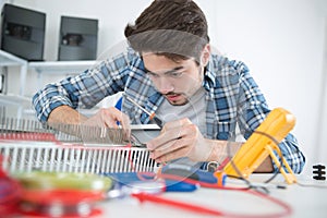 Young electrical appliance assembler at work