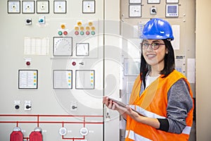 Young businesswoman standing in front of the control panel in the control room