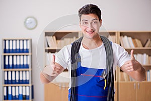 The young electrician with cable working in office