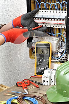 Young electrician technician at work on a electrical panel with