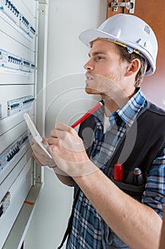 Young electrician working on electric panel