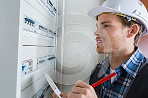 young electrician working on electric panel