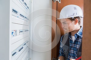 Young electrician working on electric panel