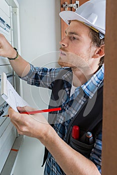 Young electrician working on electric panel