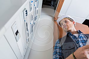 Young electrician working on electric panel