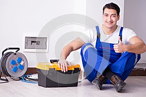 The young electrician working on socket at home