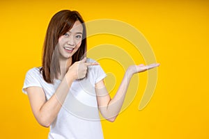 Young elegant Asian woman smiling and pointing to empty copy space