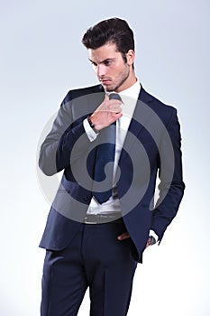 Young elegant business man fixing his tie