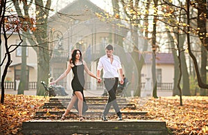 Young elegant couple passionately dancing tango in city park