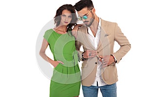 Woman in green dress leaning elbow on man`s shoulder