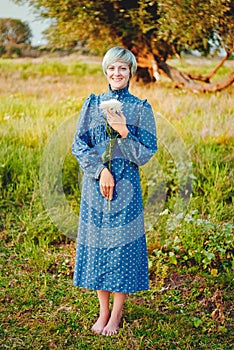 Young elegant happy lady with flower in your hands