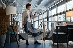 Young elegant man looking for wi-fi conncetion in the cafe