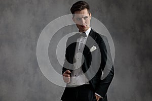 Young elegant man wearing tuxedo and looking to side