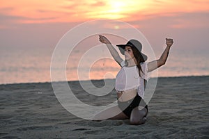 Young elegant pretty lady with a hat on the beach dawn outdoors background, portrait