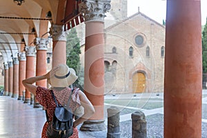 Young elegant tourist with hat looking at Piazza santo Stefano, Bologna - Italy. photo