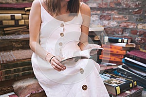 Young elegant woman choosing book in ancient secondhand bookstore Libreria Acqua Alta in Venice, Italy photo