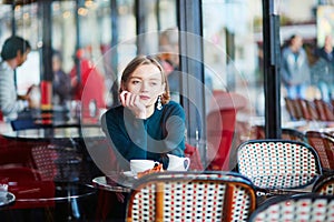 Young elegant woman drinking coffee in cafe in Paris, France