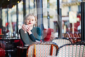 Young elegant woman drinking coffee in cafe in Paris, France